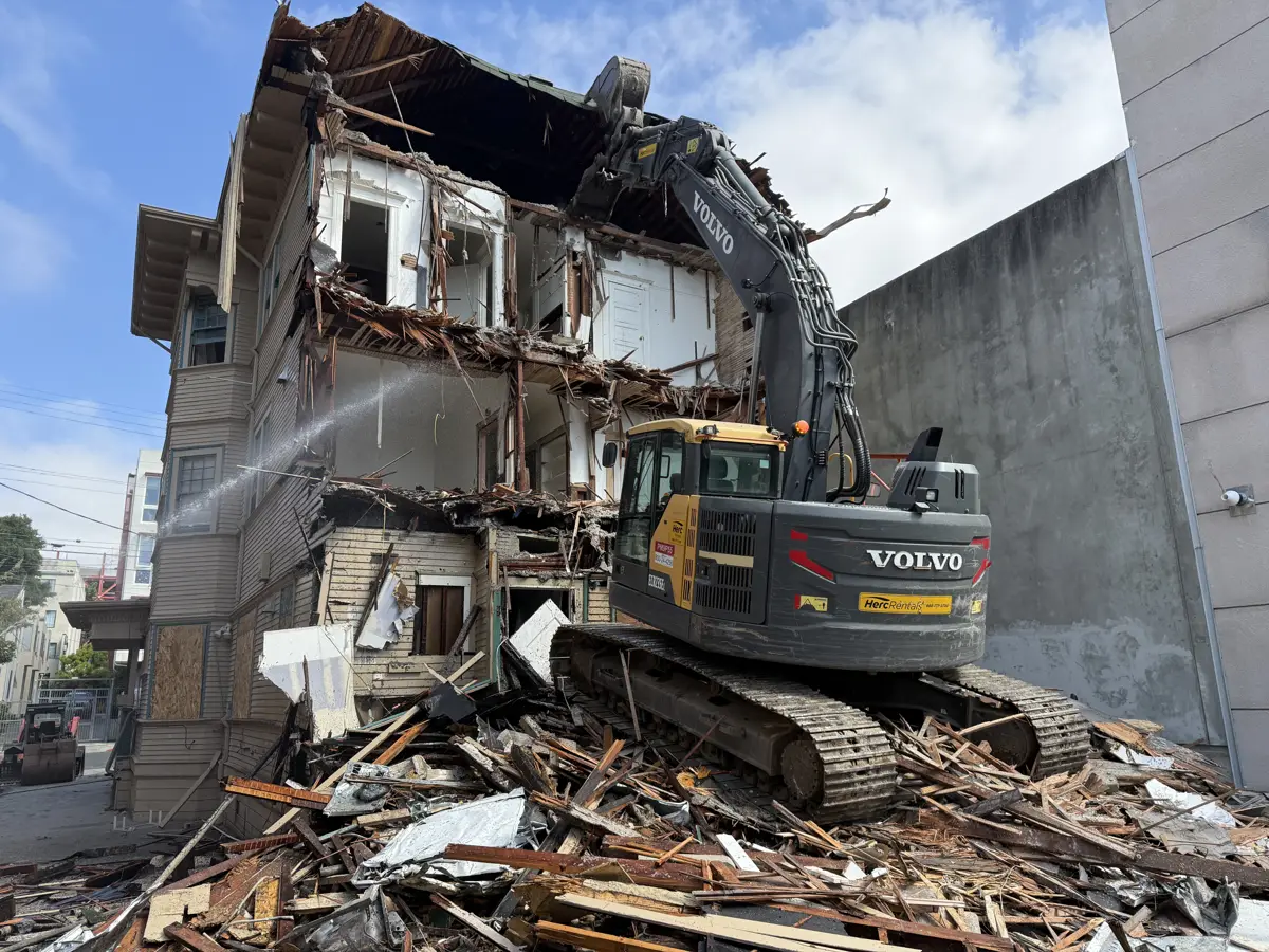 Demo Patrol excavator tearing down a house